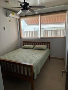 a bedroom with a bed with a ceiling fan and a window at Beach House in Coronado in Nueva Gorgona +43 photos