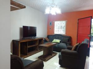 a living room with couches and a flat screen tv at Abril hospedaje in Juayúa