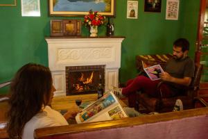 two people sitting in a living room with a fireplace at Casa Rumi - Guesthouse in La Paz