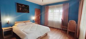 a bedroom with a large bed with blue walls at Casa Rumi - Guesthouse in La Paz