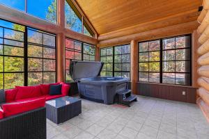 a screened in porch with a couch and a tv at Fiddler Lake Resort - Rabbit 12 in Mille-Isles