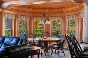 a dining room with a table and chairs and windows at Fiddler Lake Resort - Rabbit 12 in Mille-Isles