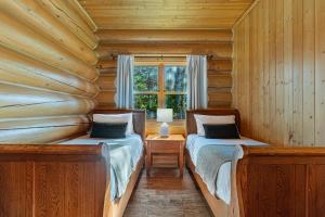 a bedroom with two beds in a log cabin at Fiddler Lake Resort - Rabbit 12 in Mille-Isles +13 photos