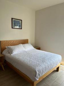 a bedroom with a bed with a wooden headboard at Gran departamento con alberca, terraza y vista a lago en Lago Luna - 5 minutos de Chante Spa in Chantepec +36 photos