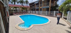 a person is standing next to a swimming pool at La Pointe d'Argent in Pointe-Noire