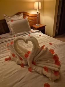 two towels in the shape of a heart on a bed at La Pointe d'Argent in Pointe-Noire