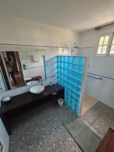 a bathroom with a sink and a toilet and a mirror at La Pointe d'Argent in Pointe-Noire