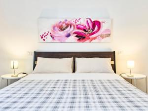 a bedroom with a bed and a painting on the wall at il 64B - 10 minuti a piedi dal Policlinico San Matteo - in Pavia