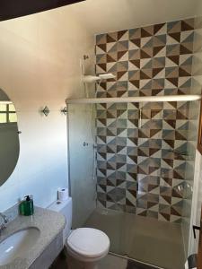 a bathroom with a toilet and a sink and a shower at Pousada Acordes do Lago in Cunha +22 photos
