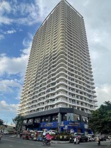 a large white building with cars parked in front of it at Modern Condo in Phnom Penh ByDN in Phnom Penh