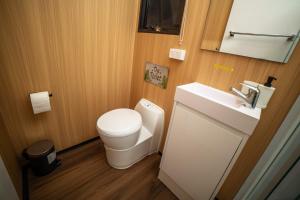 a small bathroom with a toilet and a sink at Gunyah by Tiny Away in Mount McDonald