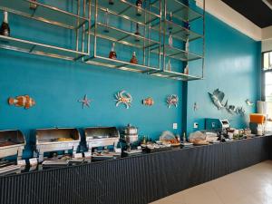 a restaurant with blue walls and a counter with food at The Green Beach Resort in Sam Roi Yot