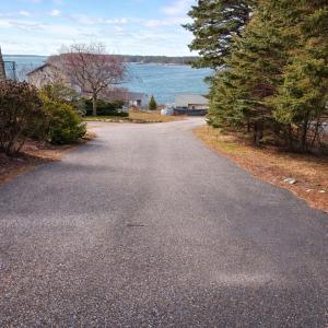 an empty road next to a body of water at Cozy Coastal Hideaway with Harbor Views in Tremont