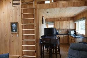 a kitchen with a spiral staircase in a log cabin at Cozy Coastal Hideaway with Harbor Views in Tremont