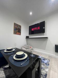 a living room with a table with a tv on the wall at Stylish 2BR Duplex - Central & Spacious in Sunderland