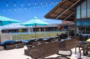 a patio with chairs and tables and umbrellas at Watermark Hotel & Spa Bali in Jimbaran