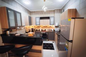 a kitchen with a refrigerator and a counter top at star Luka Luxury in Jazīrat al ‘Awwāmīyah
