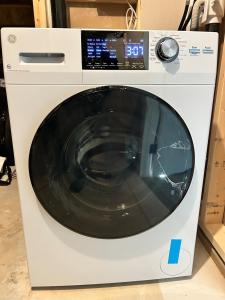 a white washing machine sitting in a room at Spacious and Stylish Private Basement Suite - 1 bed and 1 rec room in Winnipeg
