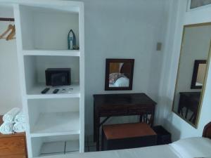 a bedroom with a bed and a desk and a mirror at Bungalow Encanto in Zihuatanejo +2 photos