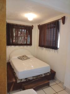 a small bedroom with a bed in a room at Bungalow Encanto in Zihuatanejo