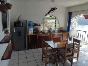a kitchen with a table and a refrigerator at Bungalow Encanto in Zihuatanejo