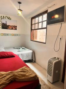 a bedroom with a red bed and a window at Uai hostel in Ouro Preto