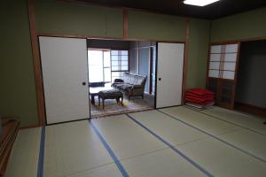 ein Zimmer mit einem Wohnzimmer mit Sofa und Stuhl in der Unterkunft あわい in Kure