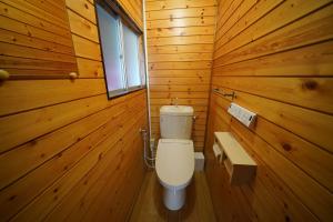 ein Badezimmer mit einer Toilette in einer Holzwand in der Unterkunft あわい in Kure + 22 Fotos