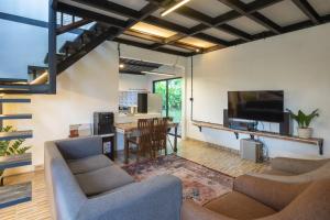 a living room with chairs and a tv and a table at Lingga Garden House in Puncak