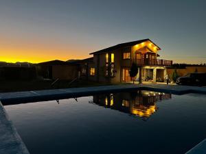 a house with a swimming pool in front of a sunset at Cabaña con Piscina para Descansar in Chihuahua
