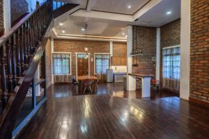 a living room with a staircase and a brick wall at Lingga Garden House in Puncak