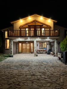 a large house with a deck on top at night at Cabaña con Piscina para Descansar in Chihuahua
