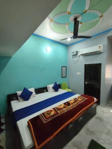 a bedroom with a large bed with a blue wall at Shri Janki Raman kunj 5 minut from ram mandir in Ayodhya