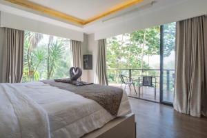 a bedroom with a large bed and a large window at Lingga Garden House in Puncak +62 photos