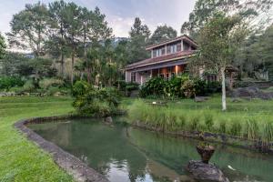 a house with a pond in front of it at Lingga Garden House in Puncak