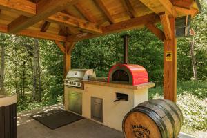 a outdoor kitchen with a stove and a barrel at Fiddler Lake Resort - Bear 14 in Mille-Isles