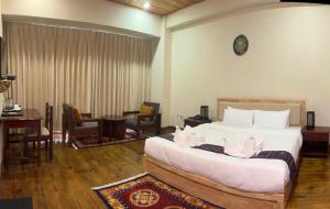 a bedroom with a large bed and a table and chairs at Taktshang Paradise in Paro