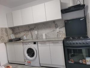 a kitchen with a stove and a washing machine at Casa Lucy in Alexandria