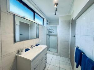 a bathroom with a sink and a mirror and a shower at Edinburgh Motor Inn in Warragul