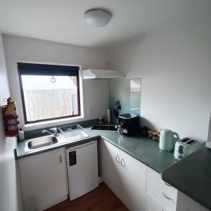 a kitchen with white cabinets and a sink and a window at #4 Glenorchy Alpine Suite in Glenorchy +13 photos