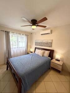 a bedroom with a bed with a ceiling fan at Charming condo with a rooftop, across beach in Coco +38 photos
