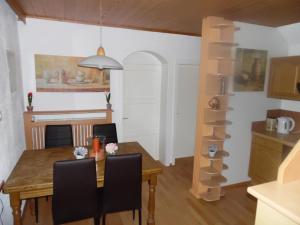 uma cozinha e sala de jantar com uma mesa de madeira e cadeiras em FeWo Katie em Radenthein