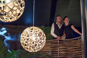 a man and a woman sitting on a bench next to a light fixture at OMIRA - Nuits d'exception & Spa in Bordeaux +5 photos