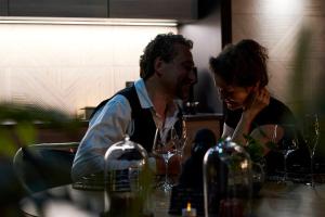 a man and a woman sitting at a bar with wine glasses at OMIRA - Nuits d'exception & Spa in Bordeaux