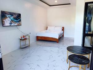 a bedroom with a bed and a table and stool at CHIEF'S VILLA Rentals Malapascua Island in Malapascua Island