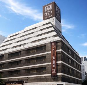 a building with a sign on the top of it at Hotel Piatt Nagoya in Nagoya