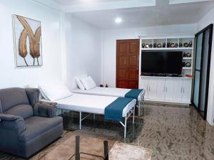 a room with a bed and a couch and a tv at CHIEF'S VILLA Rentals Malapascua Island in Malapascua Island