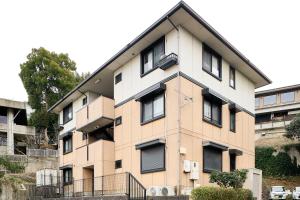 an apartment building with black shutters on it at B桜坂Sakurazaka APT in Susakiuramachi