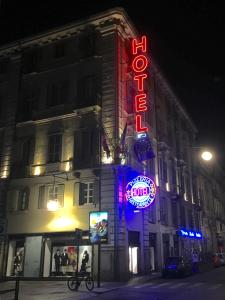 a building with a neon sign on the side of it at Le Petit Hotel in Turin