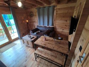 a living room with a couch and a table at Charmant petit chalet jurassien in Saint-Lamain +10 photos